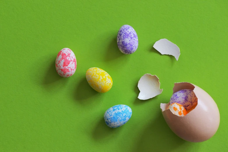 six different colors of eggs sit in a row