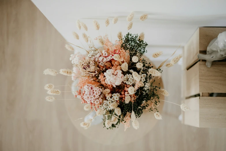 this flower arrangement is placed on the wall above an empty cabinet