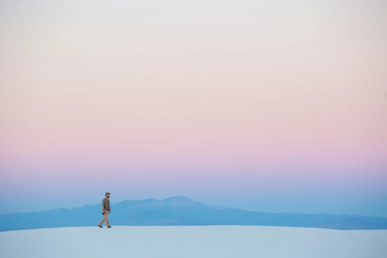 person walking on snowy surface at dusk time