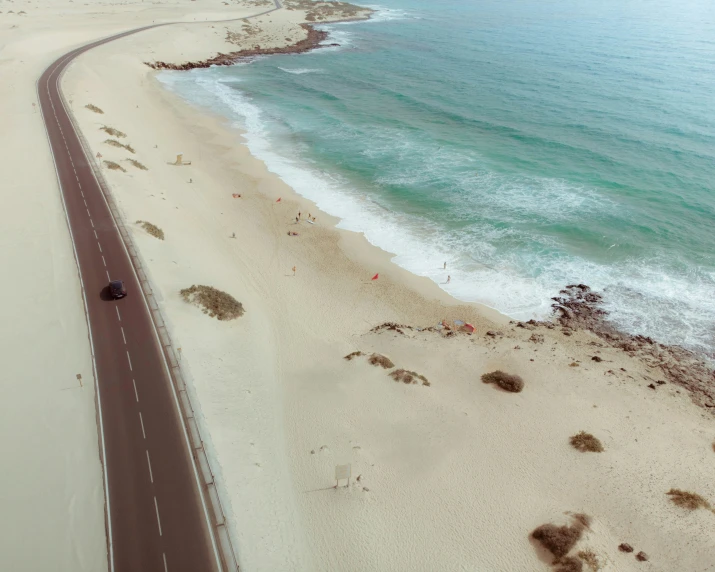 an aerial view of a stretch of highway in the desert next to the ocean