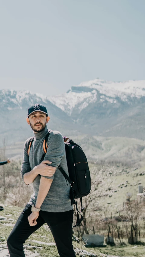 man on the edge of a cliff with mountains in background