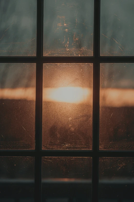 the sun shining through a window at dusk