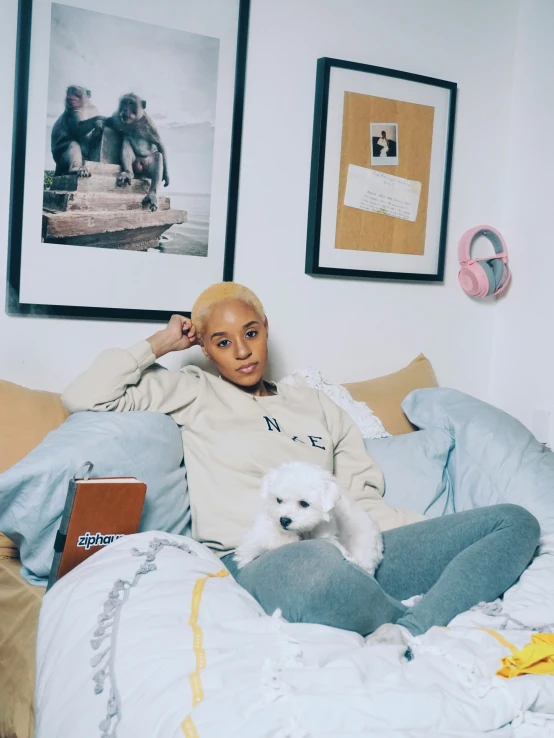 an attractive young lady is laying in bed holding her small dog