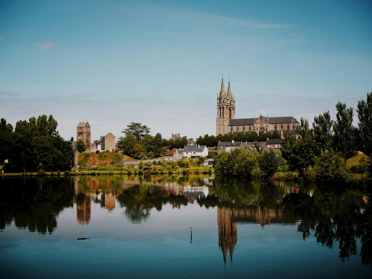 a castle surrounded by trees next to a body of water