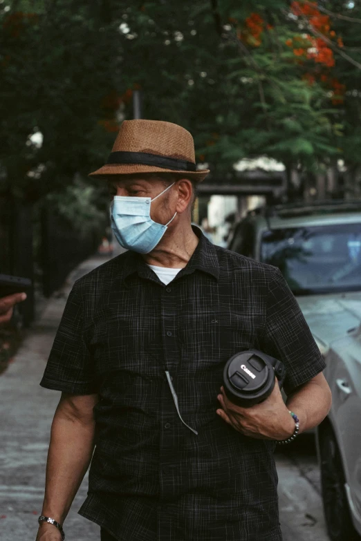 a man walking down the street wearing a face mask