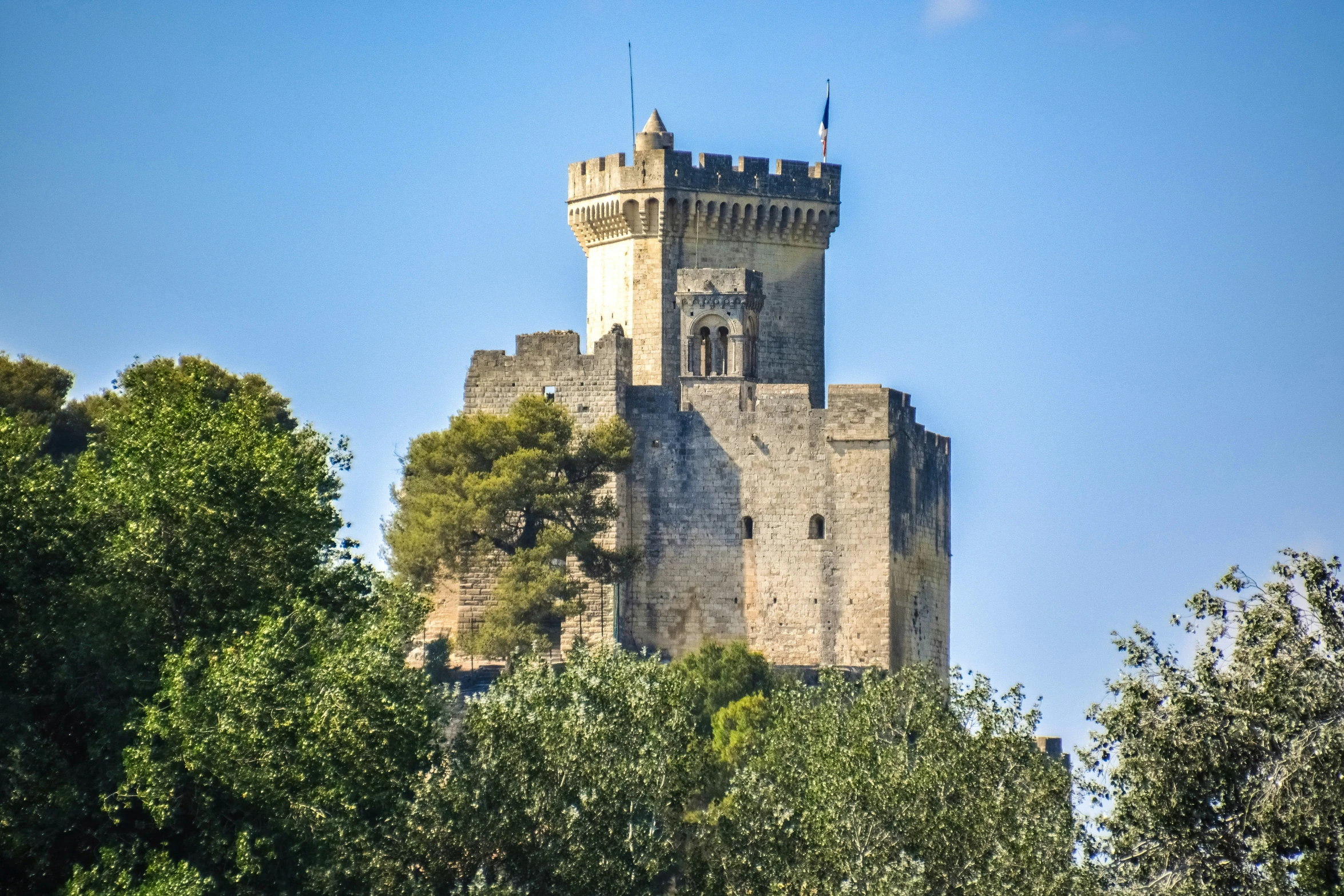 an old tower structure standing on top of a hill with trees