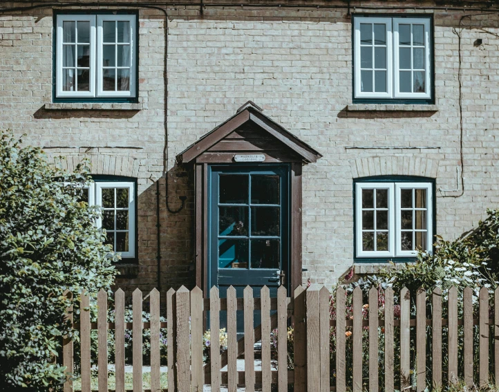 a small brick house with blue doors and windows