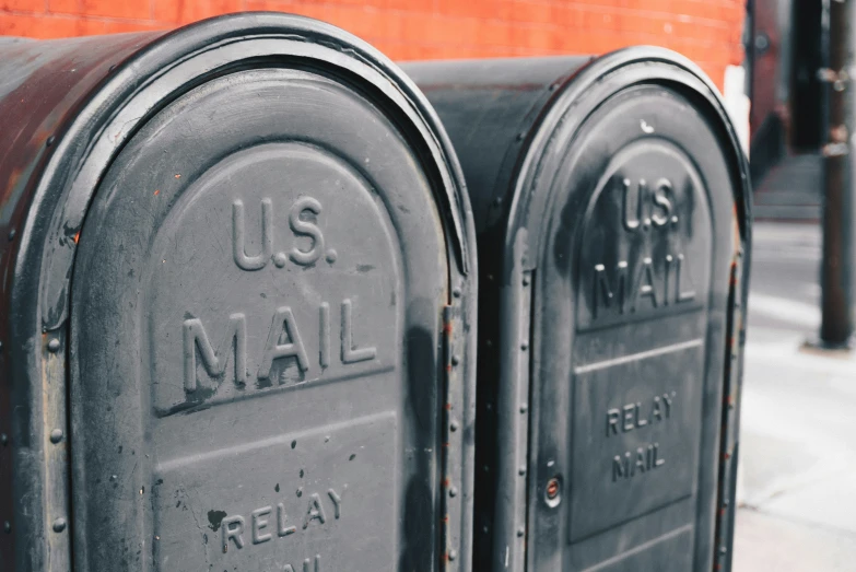 two mailboxes are next to each other on the street