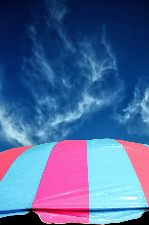 a big umbrella is in the shade of some clouds