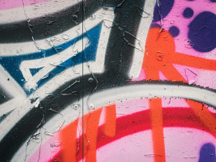 the black, white, red and blue graffiti is on the wall