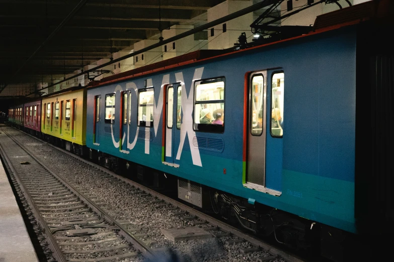 a blue train at the platform of a railway station