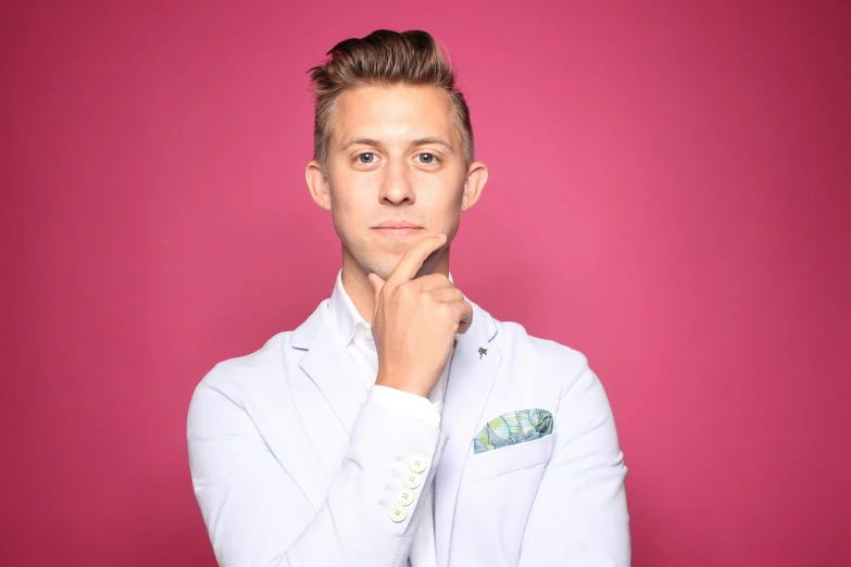 a man in a white jacket and a pink background