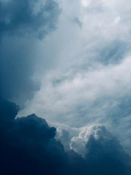 several gray clouds in the sky and dark blue sky