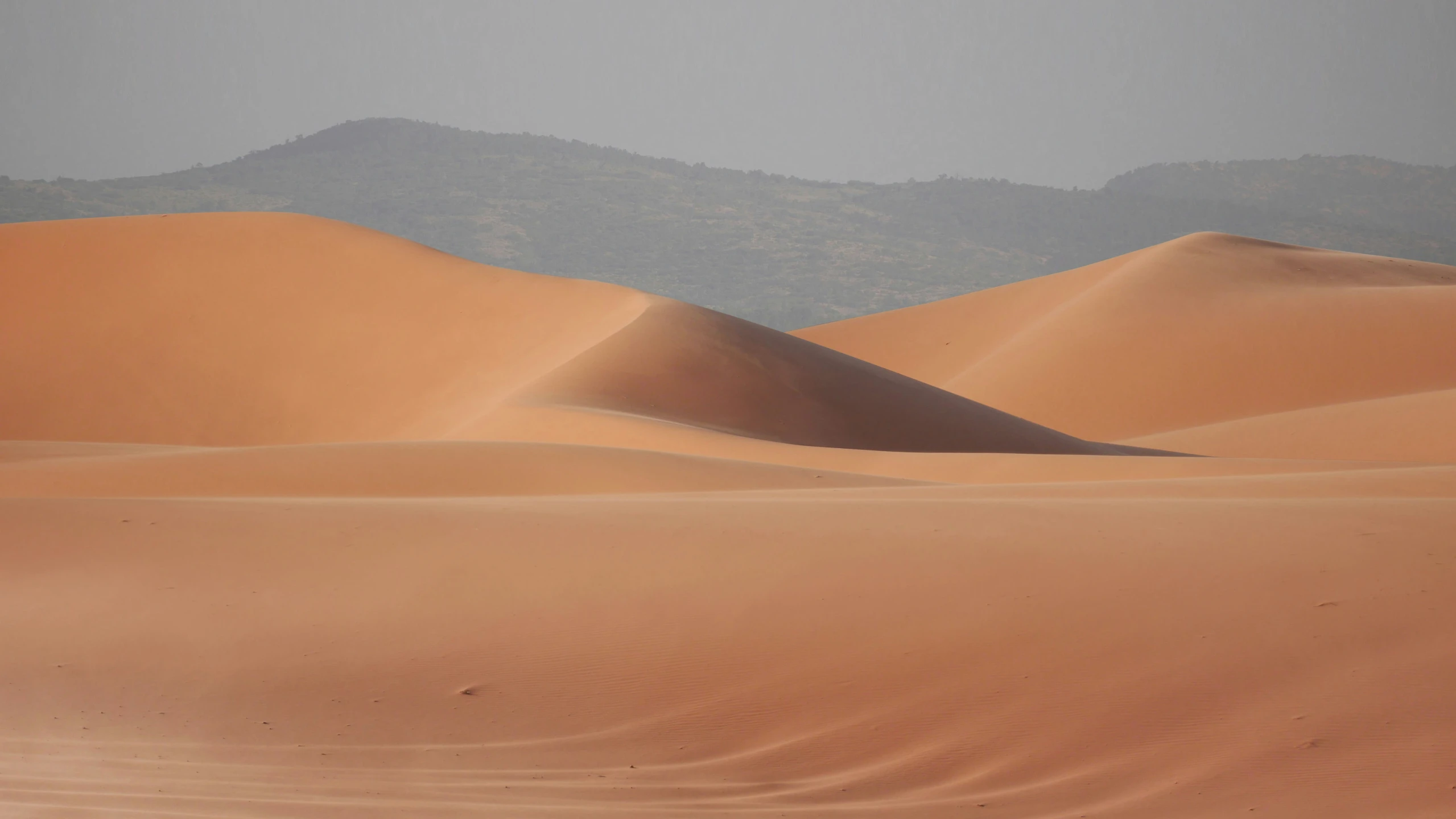 there is a mountain in the background with many dunes in it