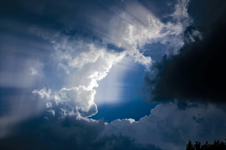 the sun is shining through some fluffy clouds