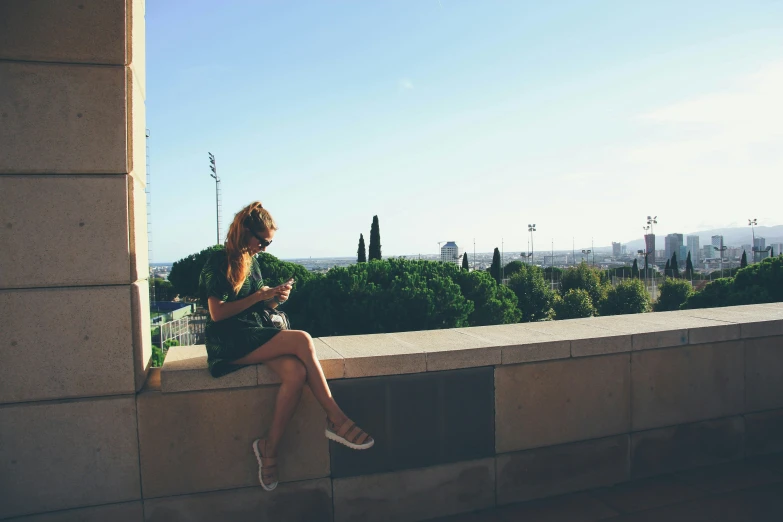 a woman is sitting outside using her cell phone