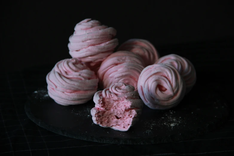 pink frosted pastries piled up on a plate