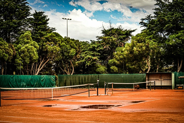 a tennis court with some trees in the background