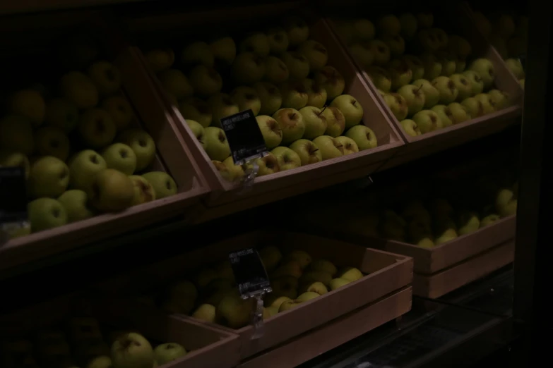 shelves with several boxes of green apples for sale