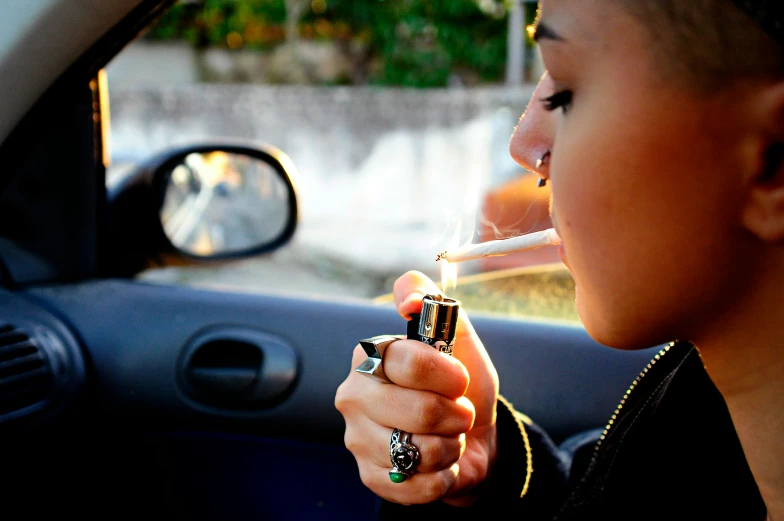 a woman smoking an electronic cigarette in a car