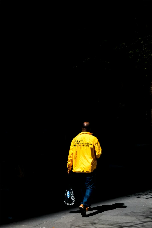 a man in a yellow coat walking towards the street