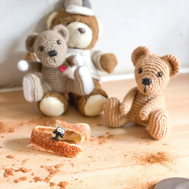 a couple of little stuffed animals on a wooden table