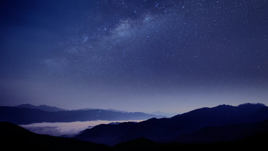 the sky is very dark blue with little clouds and stars