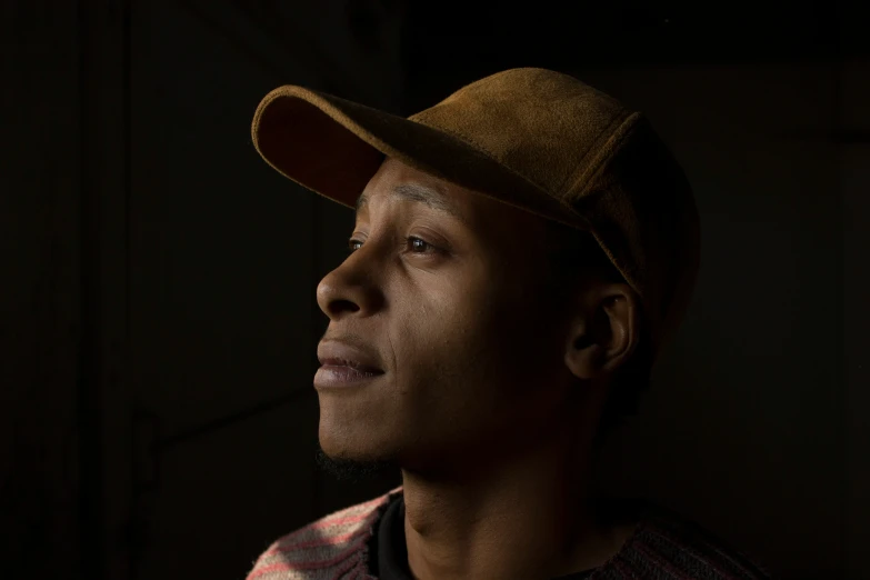 a man in a hat and plaid shirt looking ahead