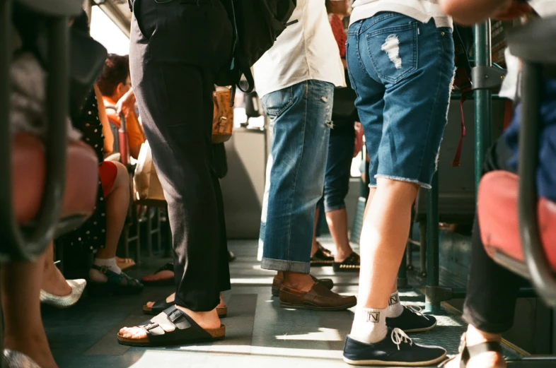 the backsides of people standing in line next to each other