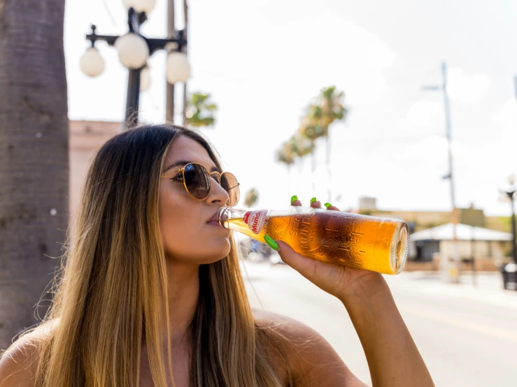 a beautiful young woman drinking a glass of beer