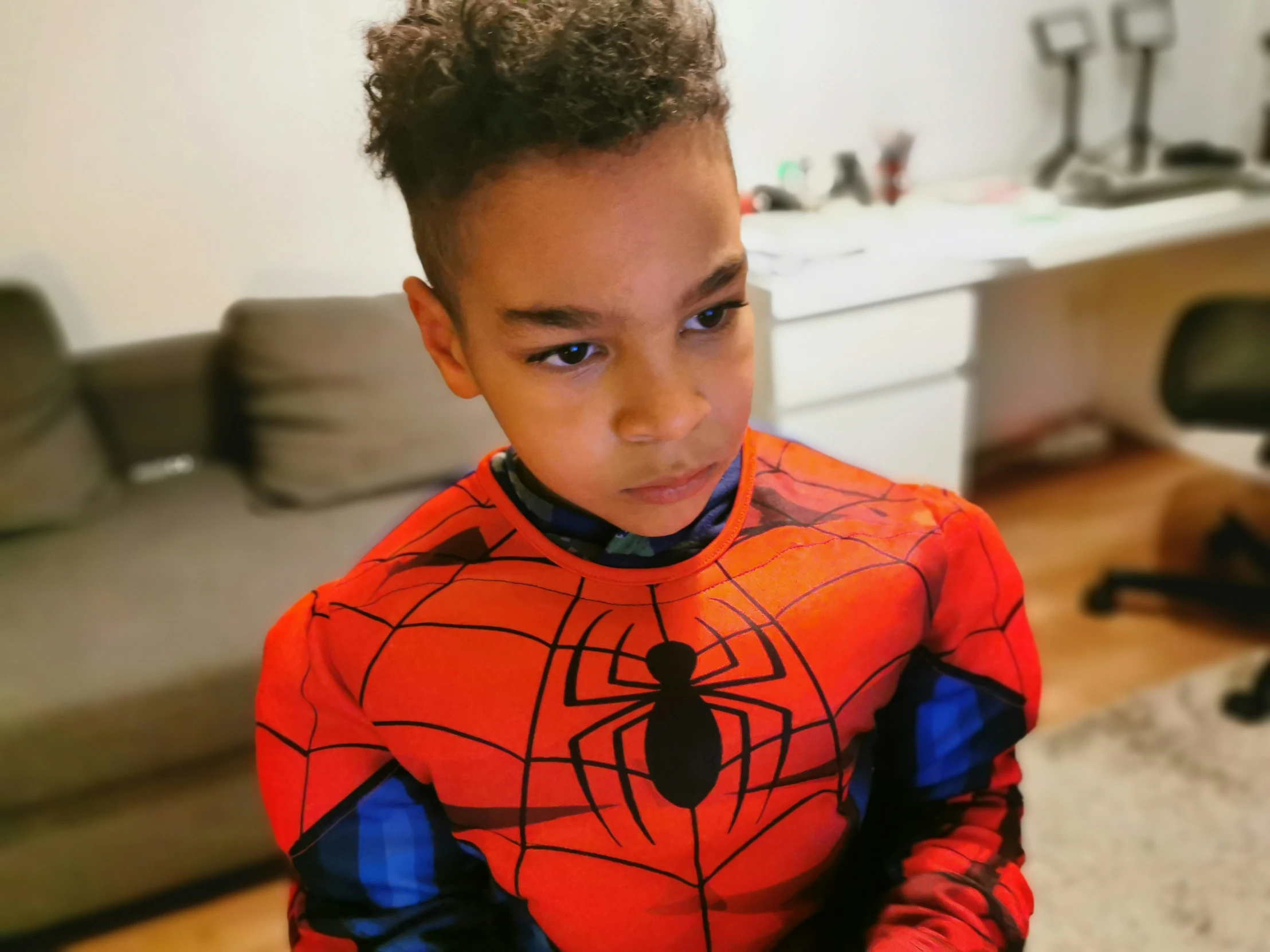 a  wearing a spider - man costume in a living room