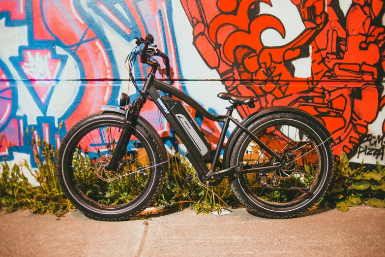 the bicycle is leaning against the wall with graffiti