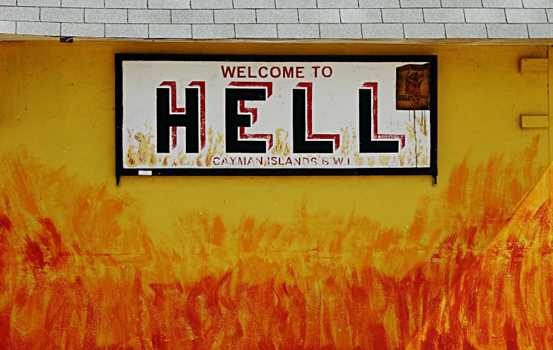 a sign reading'welcome to hell written in neon paint on a wall