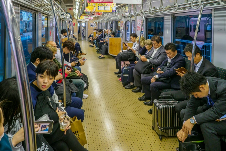 people riding a subway on the same vehicle as a person on the other car