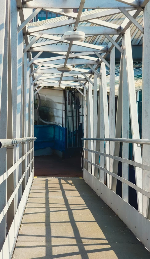 a white bridge with shadows on the railings