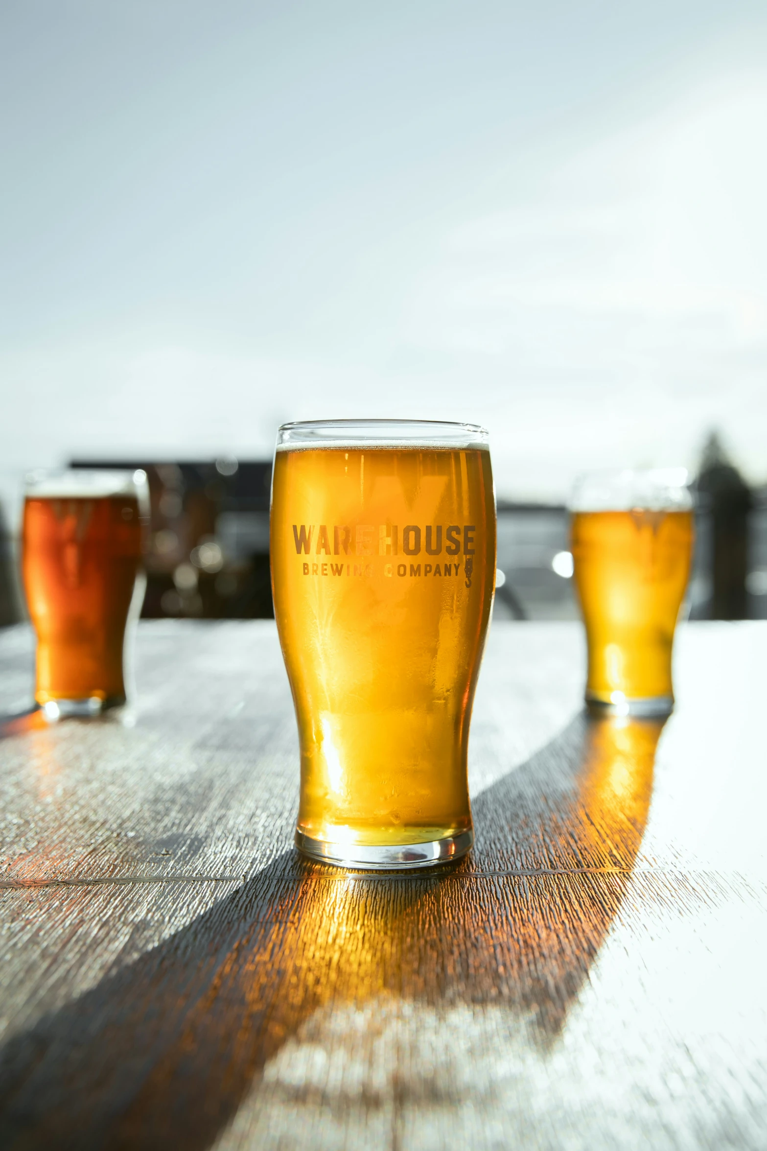 three glasses of beer sit on a table