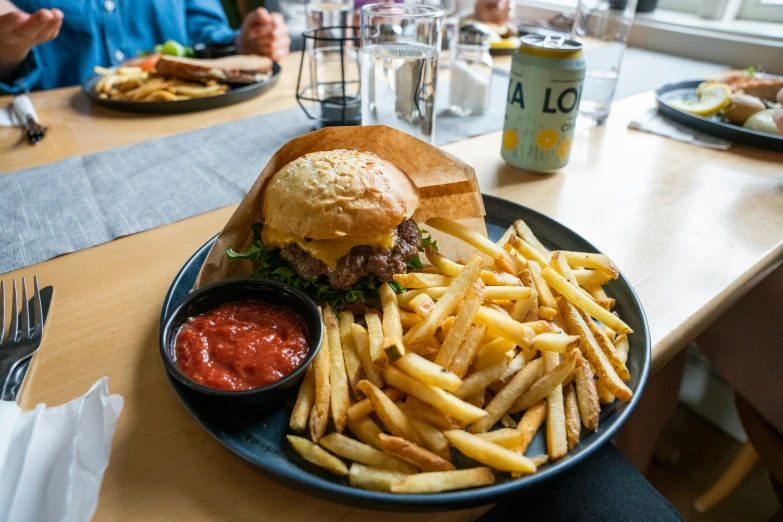 a plate of french fries next to a hamburger and coleslaw