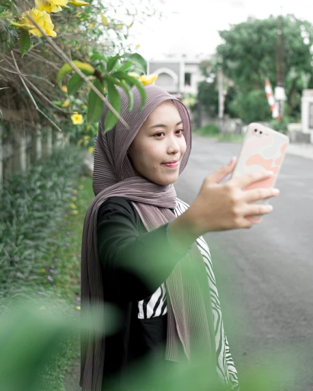 a woman wearing a hijab using her cell phone