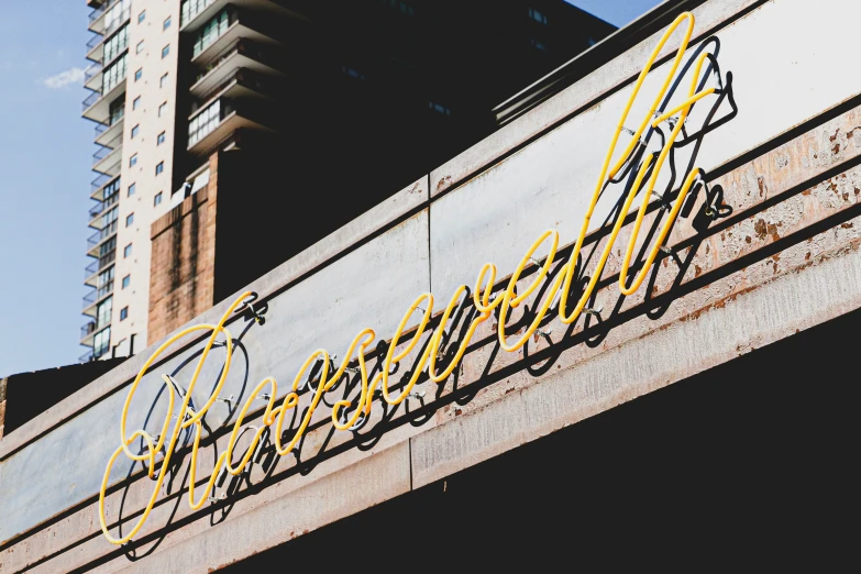 a sign on a wall with a building in the background