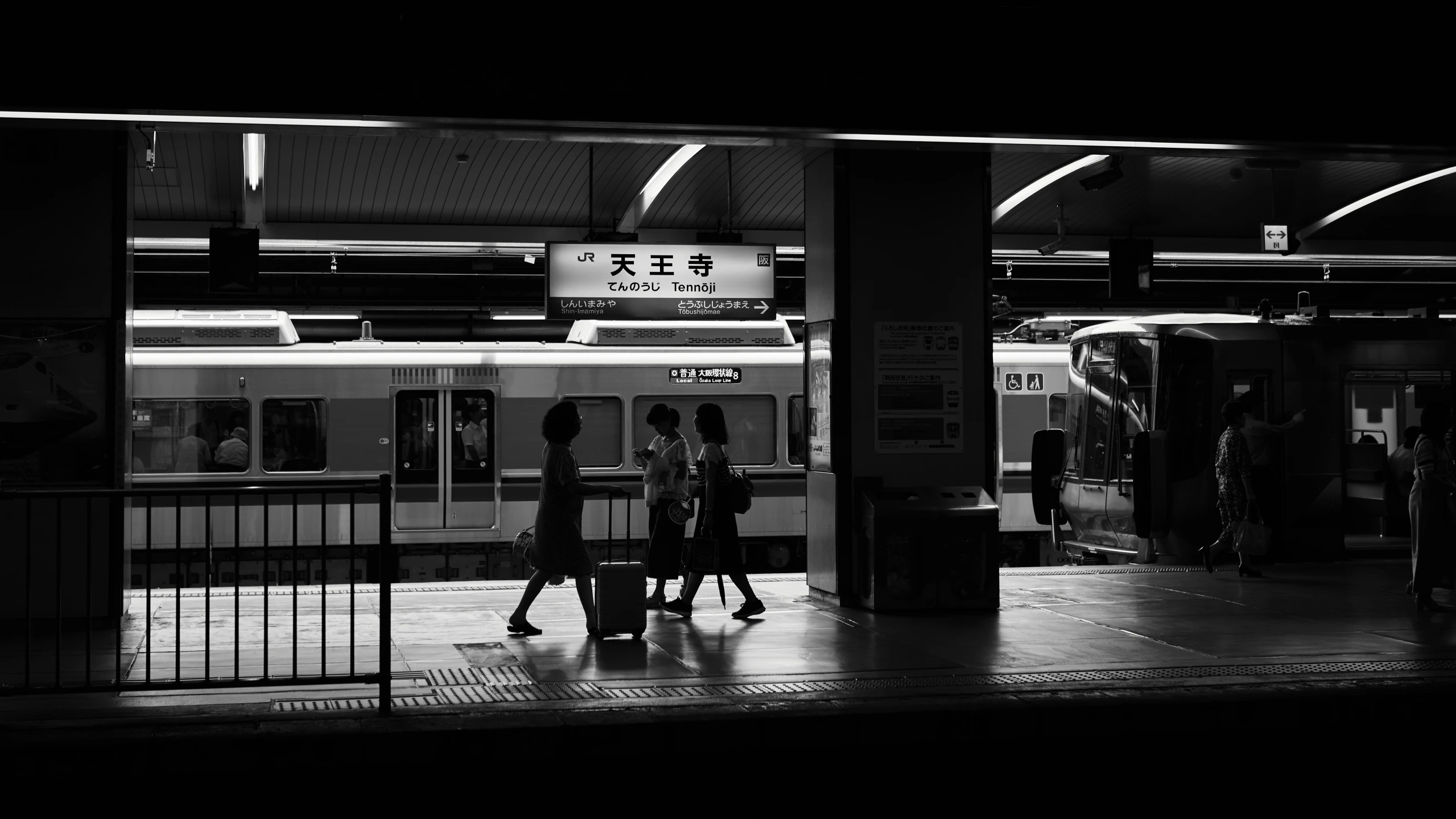 two people walking past a subway in the dark