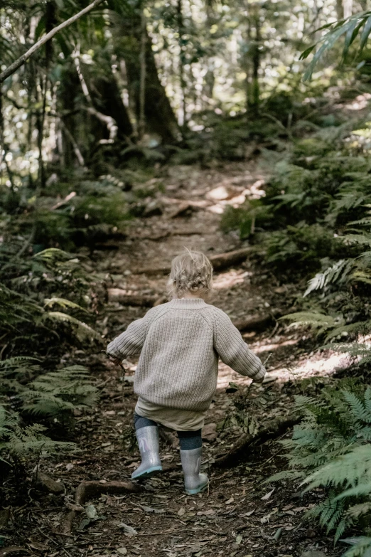 a young child runs through a forest path