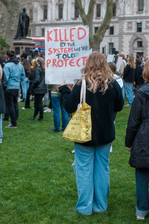 two people holding a protest sign at the end of a demonstration