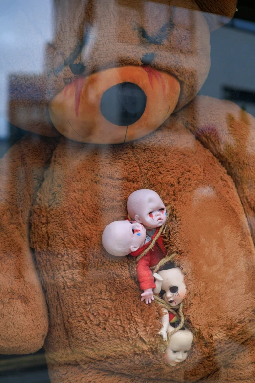 a stuffed bear is shown as an infant doll