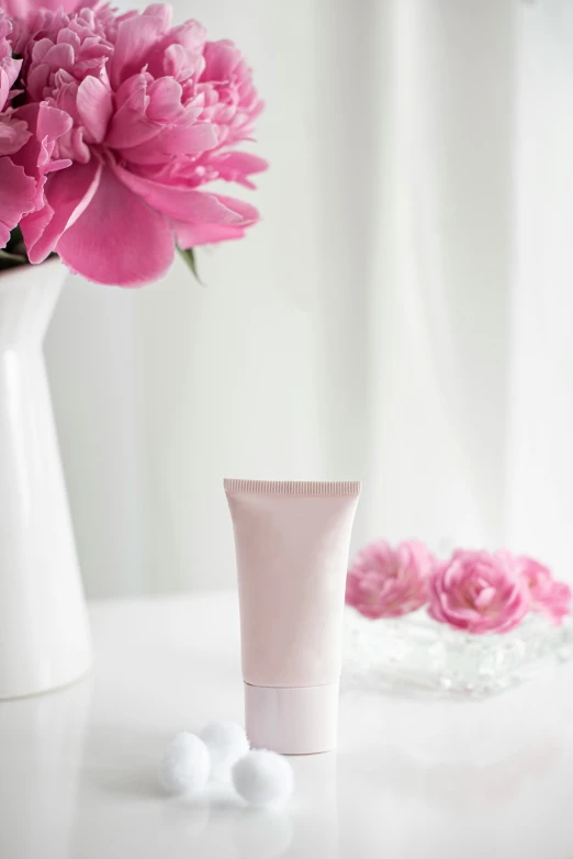 a cup with some flowers and two tubes next to it