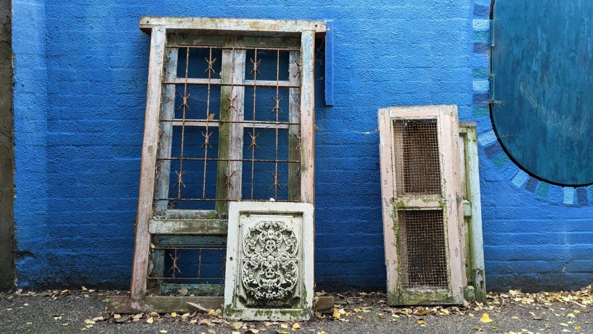 a couple of doors standing next to a blue wall