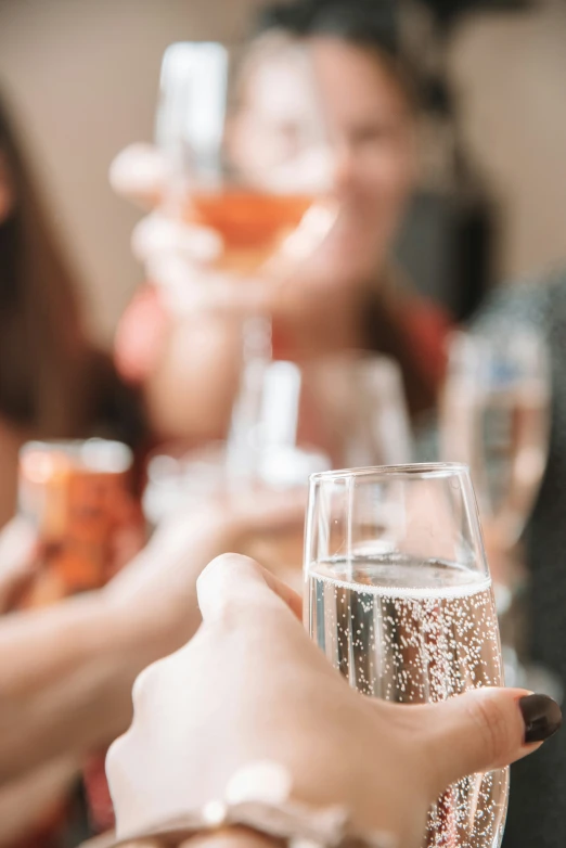 a close up of wine glasses being held by people