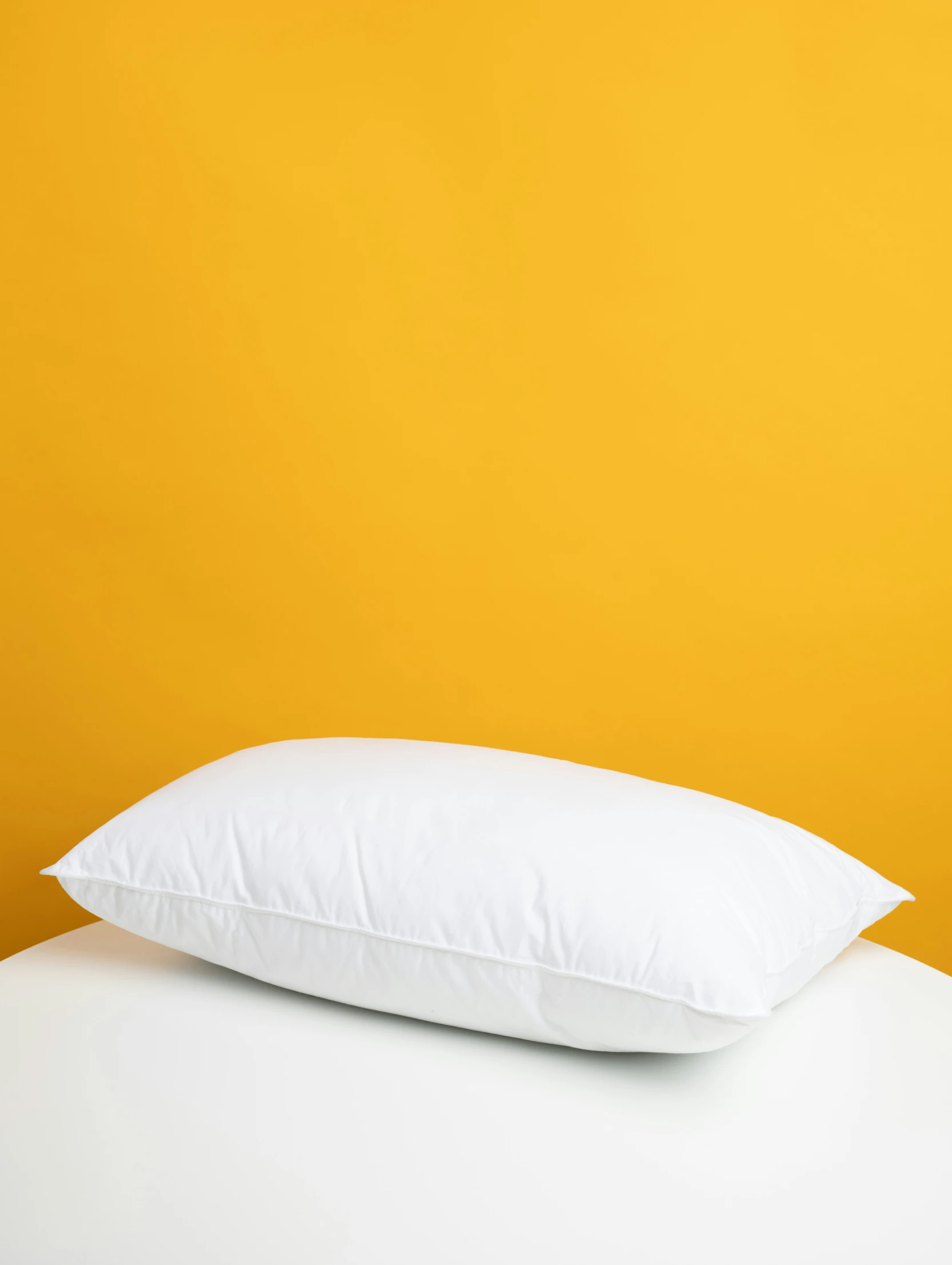 white pillows against a bright yellow background