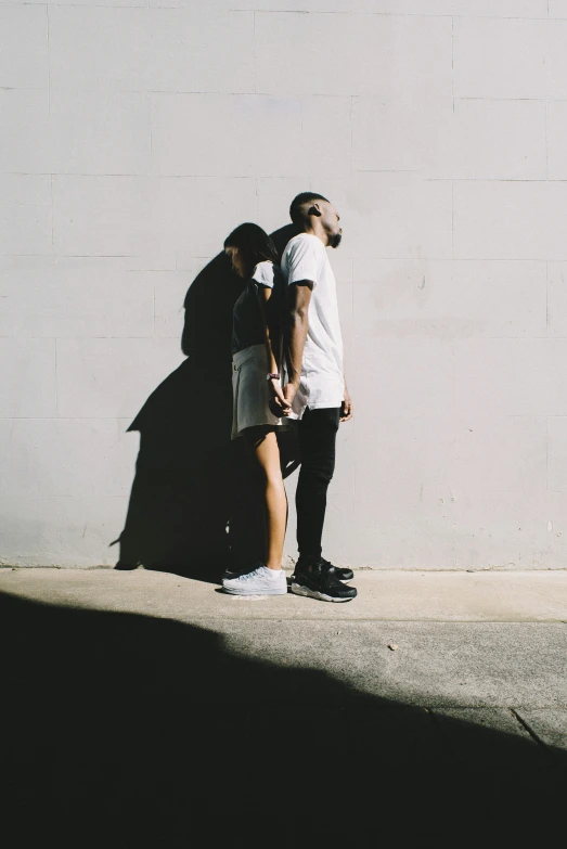 an image of a man and a woman standing in shadow