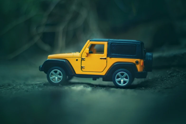 a toy jeep with trees and a rock