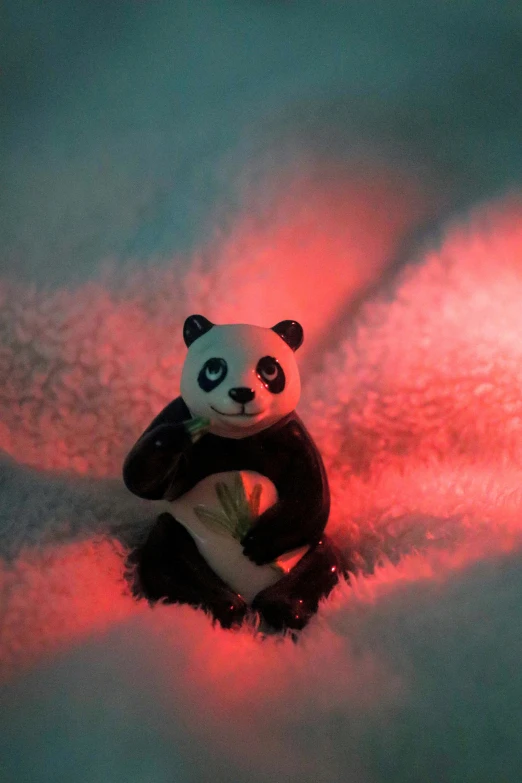 a stuffed panda bear sitting in a snow field